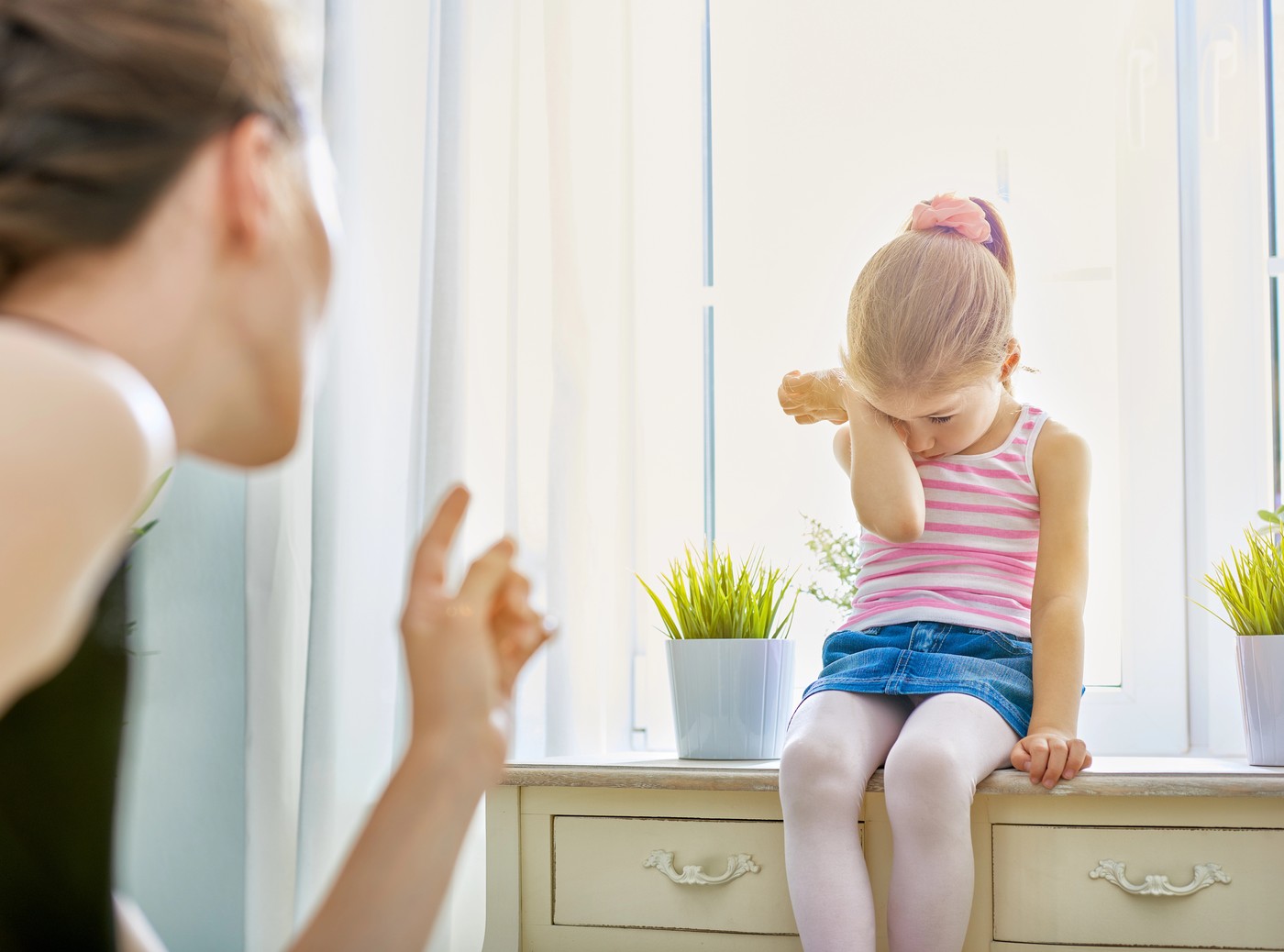 Mati med pogovorom graja žalostnega otroka v dnevni sobi