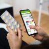 Oseba prek mobilnega telefona kupuje prehranska dopolnila na spletu.