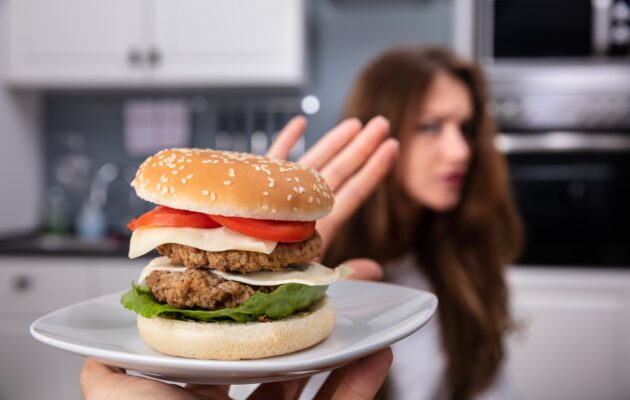 Ženska v vročem vremenu odklanja burger zaradi zmanjšanega apetita