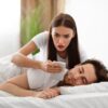 Ženska z zaskrbljenim izrazom gleda v telefon ob partnerju
