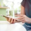 Roka s telefonom v roki in prstom, ki išče pomoč