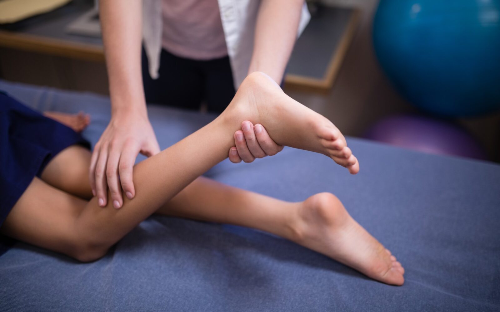 Fizioterapvtka izvaja vaje za okretnost pi otroku z Duchennovo mišično atrofijo