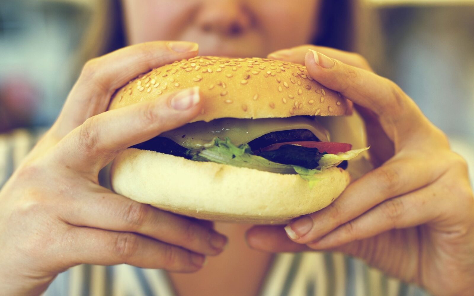 Ženska drži hamburger pred obrokom