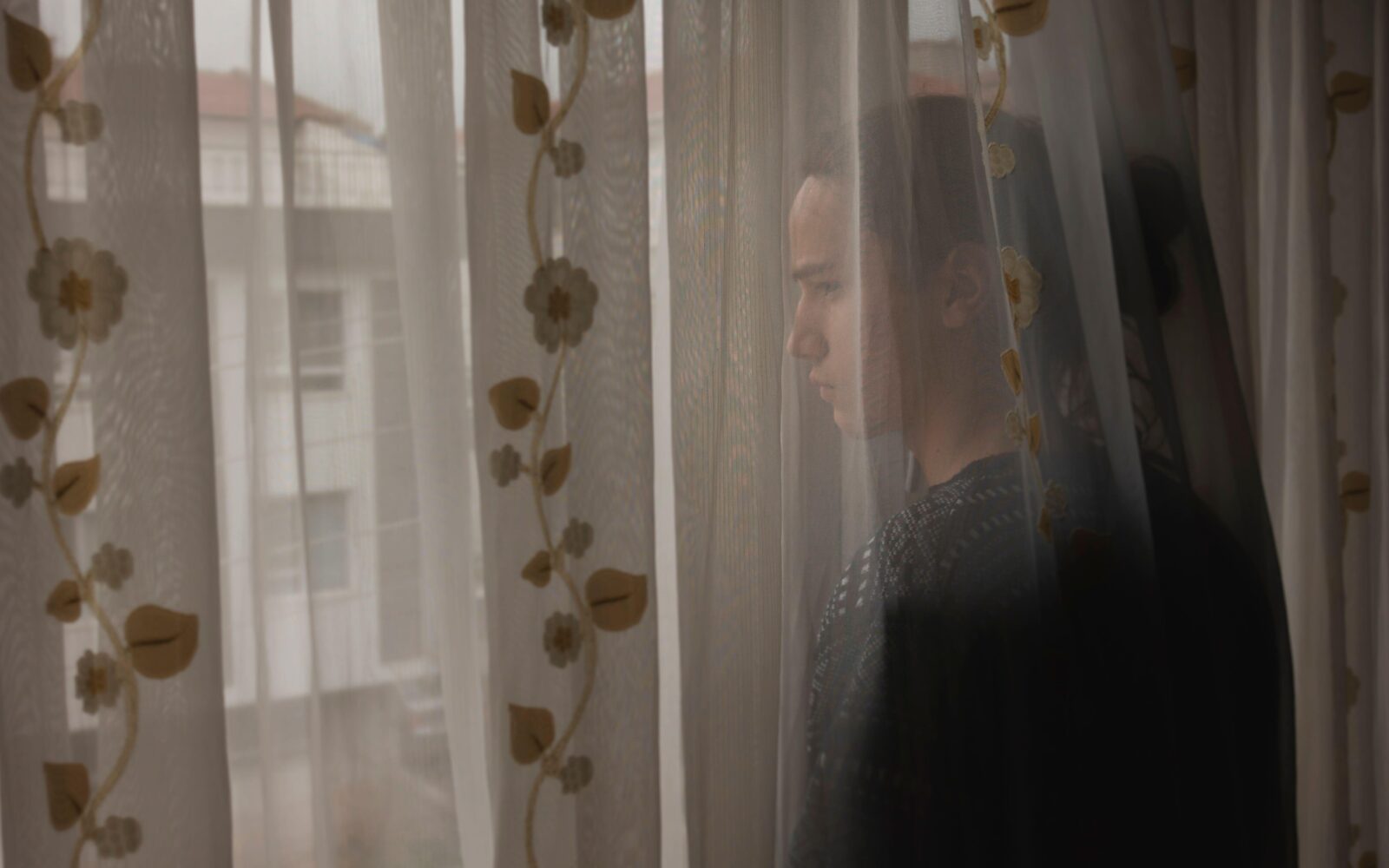 Najstnica žalostno gleda skozi okno in je tesnobna zaradi vremena in jesenskih obveznosti