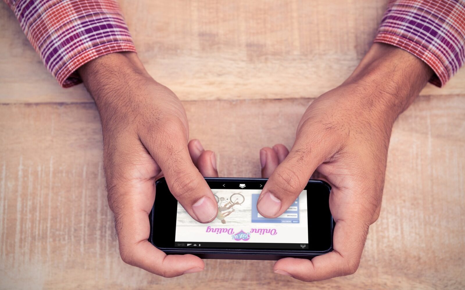 Moški v rokah drži mobilni telefon