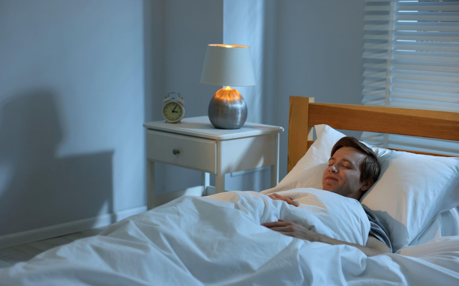 Moški spi ob prižgani nočni svetilki - to lahko vpliva na kakovost spanca in zdravje srca.