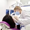 Zobozdravnica med posegom; pacienti zaradi cen in čakalnih dob zdravljenje zob iščejo tudi v tujini