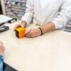 Oseba v lekarni pri pultu plačuje s kartico - ena od površin, ki se je pogosto dotika ogromno ljudi, zato je tam možnost prenosa okužbe večja