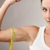 Ženska kaže svoje bicepse, okoli katerih ima meter