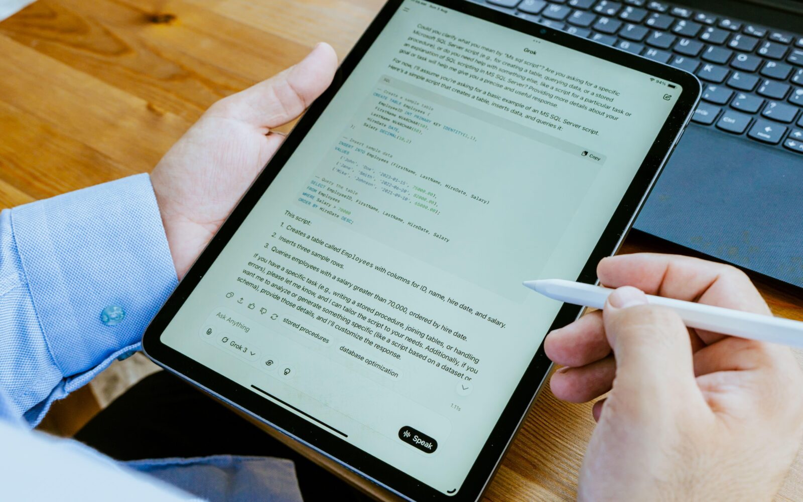 Moški v rokah drži tablico in uporablja ChatGpt, klepetalnik z umetno inteligenco.